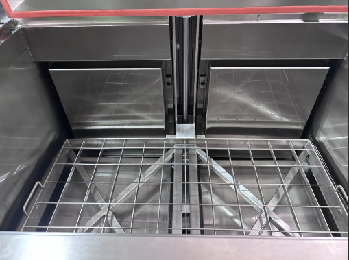 Inside a stainless steel cleaning tank with a wire basket