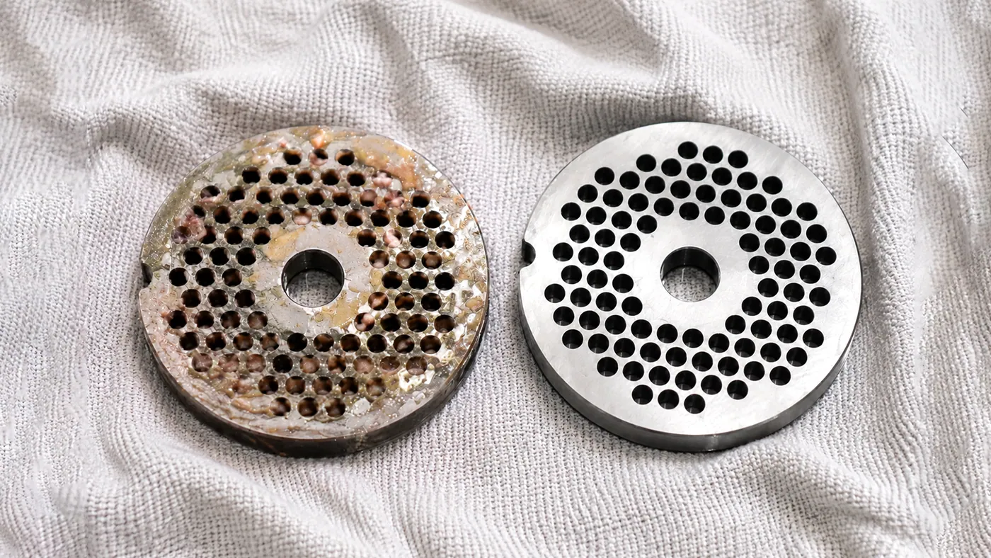A soiled and a cleaned mincer hole plate